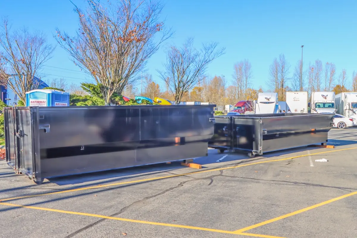 Professional dumpster rental service with roll-off container on residential driveway in Braddock
